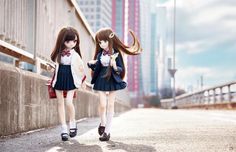 two dolls are walking down the street with their hair blowing in the wind and wearing school uniforms