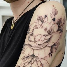 a woman with a black and white flower tattoo on her arm