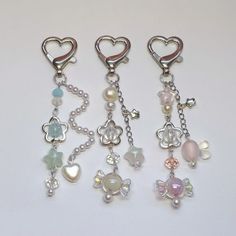 four charms with hearts and pearls hanging from them