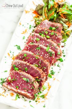 steak with sesame seeds and garnish on a white platter, ready to be served