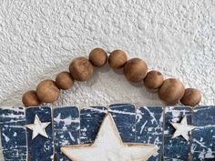 a wooden sign with two stars on it and some wood beads hanging from the front