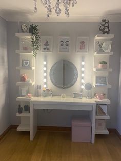 a white desk topped with lots of drawers under a mirror and lights on the wall