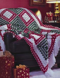 a living room with a couch covered in a blanket and christmas presents on the floor