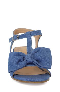 A tacked faux leather bow adorns the toe of a T-strap dress sandal that is set on a trendy block heel. 1.5" heel Adjustable ankle strap with buckle closure Water-resistant Manmade upper and sole Imported Denim Sandals With Buckle Closure For Spring, Spring Denim Sandals With Buckle Closure, Summer Denim Block Heel Shoes, Summer Denim Block Heel Heels, Summer Denim Block Heel, Blue Bow Sandals For Spring, Spring Bow Strap Sandals With Round Toe, Denim Blue Block Heel For Spring, Denim Blue Block Heel Heels For Spring