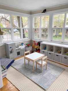 a child's playroom with lots of windows and toys on the rugs