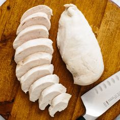 sliced chicken on a cutting board next to a knife