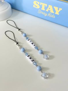 three blue and white beaded necklaces sitting on top of a table next to a book