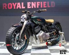 the motorcycle is on display in front of a wall with a sign that says royal enfield