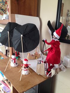 an elf is standing on a table with her umbrella and other items in front of her