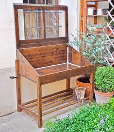 a wooden bench sitting next to a potted plant on the side of a building