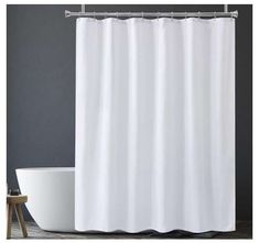 a white shower curtain next to a bath tub