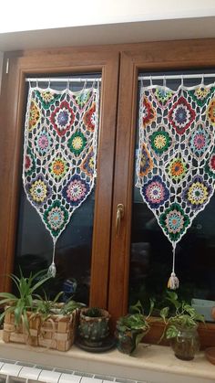 two stained glass windows with potted plants on the window sill next to each other