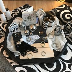 a black and white coffee table with silverware on it, surrounded by other decorative items