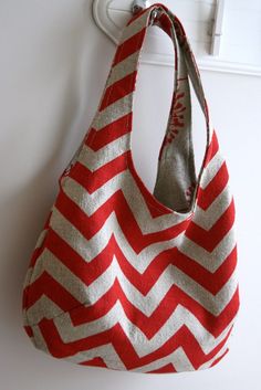 a red and white chevroned bag hanging from a hook on a door handle