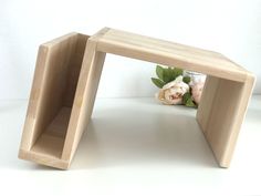 two wooden shelves with flowers in them on a white surface, one is open and the other is closed