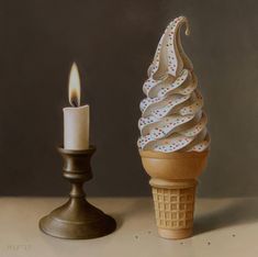 an ice cream cone next to a lit candle