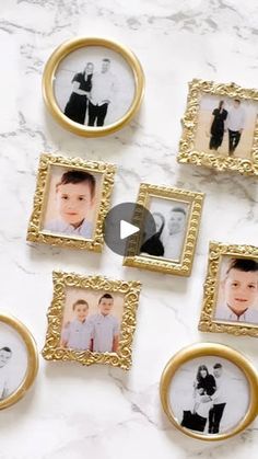 several small gold frames are arranged on a marble counter top with photos of babies in them