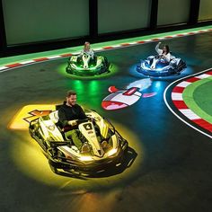 three people riding bumper cars on a race track