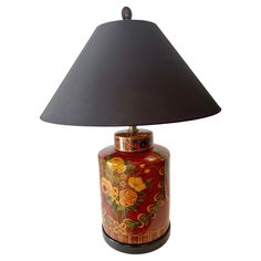 a red and gold vase lamp with a black shade