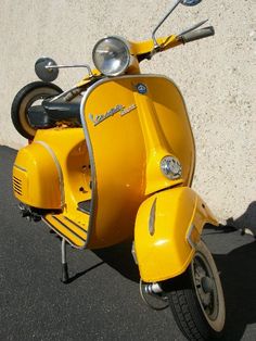 a yellow scooter parked next to a wall