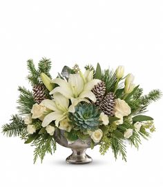 a silver vase filled with white flowers and pine cones