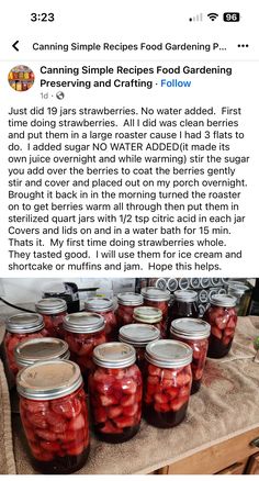 jars filled with pickled strawberries sitting on top of a table next to a wooden cutting board