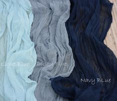 four different colors of sheer fabric laying on top of each other, one blue and the other gray