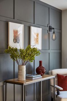 a living room with two vases and pictures on the wall