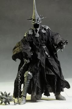 a statue of a man dressed in black and wearing a horned headdress, holding a knife