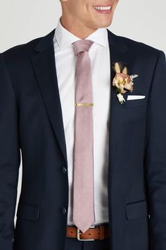 a man wearing a suit and tie with a flower on his lapel