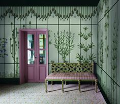 a bench in front of a green wall with plants on it and a pink door