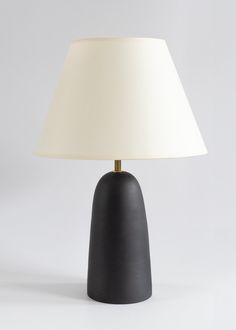 a black table lamp with a white shade