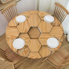 a wooden table with white plates and silverware on it