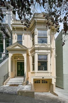 a two story house with a garage in front of it and stairs leading up to the second floor