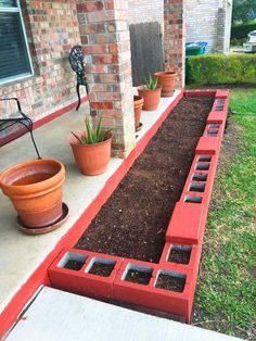 a garden bed with plants in it on the side of a house