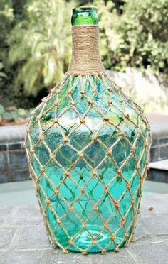 a green glass bottle with rope wrapped around it