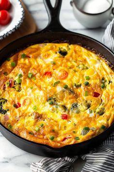 an omelet in a cast iron skillet on a marble table