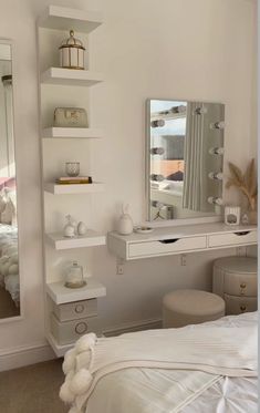 a bedroom with a bed, mirror and dressing table