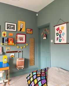 a child's bedroom with blue walls and pictures on the wall above the bed