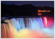 niagara falls lit up in rainbow colors at night