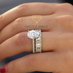 a woman's hand with a diamond ring on top of her finger and the other hand holding an engagement ring