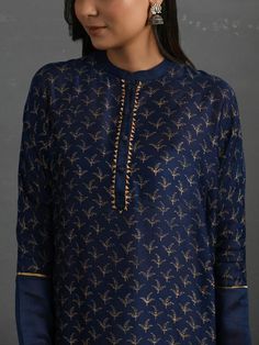 A free-size flowy Indigo chanderi kurta with gold block print, gota detail and pleated hem. Garment measurements (in Inches): Free size: Length - 47", Bust - 61", Waist - 60" Fabric: Chanderi (Cotton silk) Color: Indigo Fit: Model height - 5"7" Fit - Loose/comfortable Technique: Hand block printed in gold with gotta details Instructions: Dry clean only Note: Available in other colors This product will be shipped within 20-25 days of the order placed Gold Long Sleeve Slub Silk Kurta, Gold Cotton Silk Kurta With Chikankari Embroidery, Gold Kurta With Chikankari Embroidery In Cotton Silk, Silk Straight Kurta With Printed Motifs, Transitional Gold Cotton Silk Kurta, Traditional Silk Palazzo Set With Block Print, Long Sleeve Cotton Silk Kurta With Gota Work, Silk Straight Kurta Tunic For Eid, Gold Straight Kurta With Chikankari Embroidery