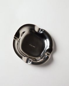 a black and silver plate sitting on top of a white table