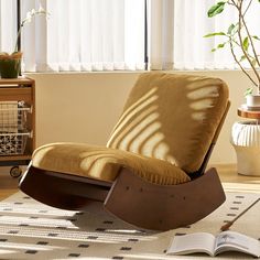 a brown rocking chair sitting on top of a rug