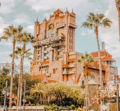 an old building with palm trees in the foreground and a sign that says hollywood