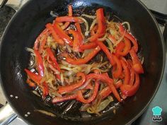 red peppers are being cooked in a wok on the stove top with other cooking ingredients