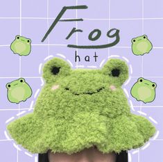 there is a frog hat on top of a woman's head in front of a tiled wall