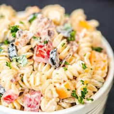 a white bowl filled with pasta salad on top of a table