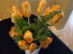 some food is sitting in a white cup on a black tablecloth with parsley