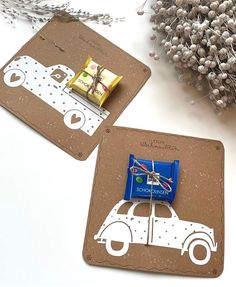 two coasters with chocolate and candy in the shape of a car on them next to some dried flowers